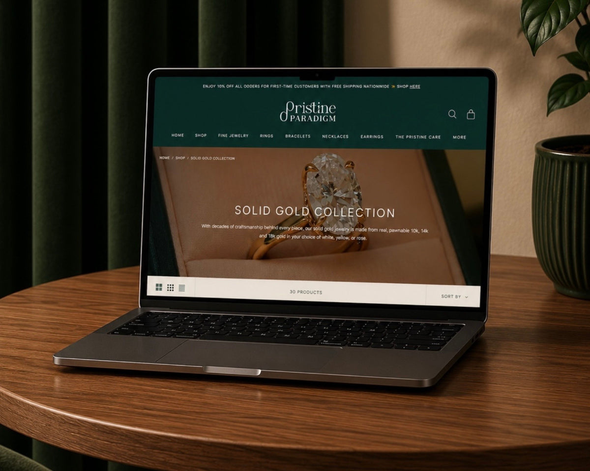 Laptop displaying the Pristine Paradigm jewelry website featuring the Solid Gold Collection