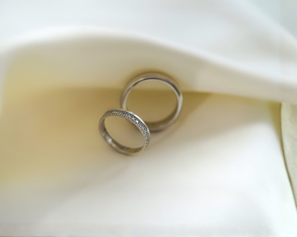 Elegant diamond wedding rings displayed on soft white satin fabric