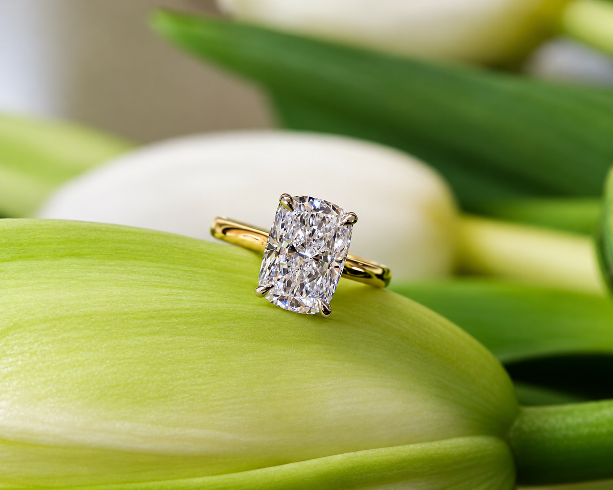 Cushion-cut diamond engagement ring on a green flower
