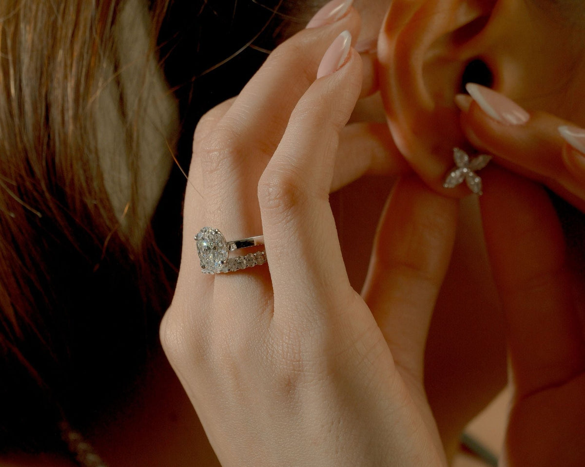 Oval lab-grown diamond ring paired with a diamond band and floral diamond earrings for a modern jewelry look